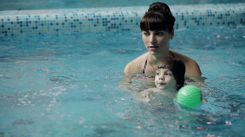 Junge Eltern im Pool seinen Sohn unterrichtend, unter Wasser zu schwimmen