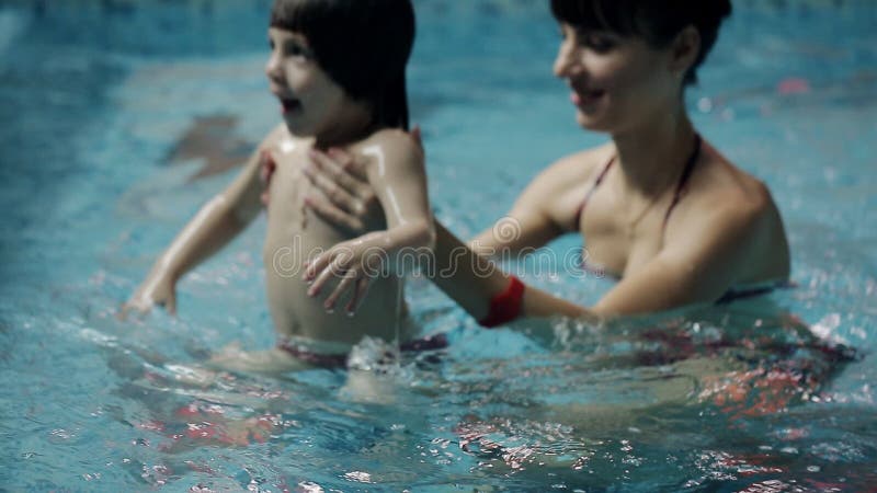 Junge Eltern im Pool seinen Sohn unterrichtend, unter Wasser zu schwimmen