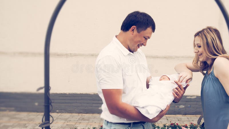 Junge Eltern mit einer Neugeborenen Stellung unter einem Bogen in der Nähe der perinatalen Zentrum lizenzfreies stockbild