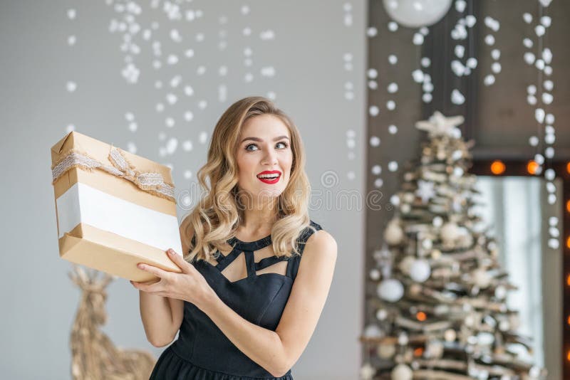 Junge emotionale Frau hält ein Geschenk und Lächeln Konzept des glücklichen Weihnachten und des neuen Jahres, Winter, Partei stockfotos Junge emotionale Frau hält ein Geschenk und Lächeln Konzept des glücklichen Weihnachten und des neuen Jahres, Winter, Partei stockfotos