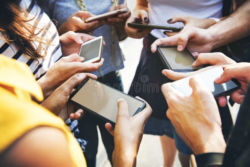 Junge erwachsene Freunde, die zusammen Jugendcu der Smartphones draußen verwenden stockfoto