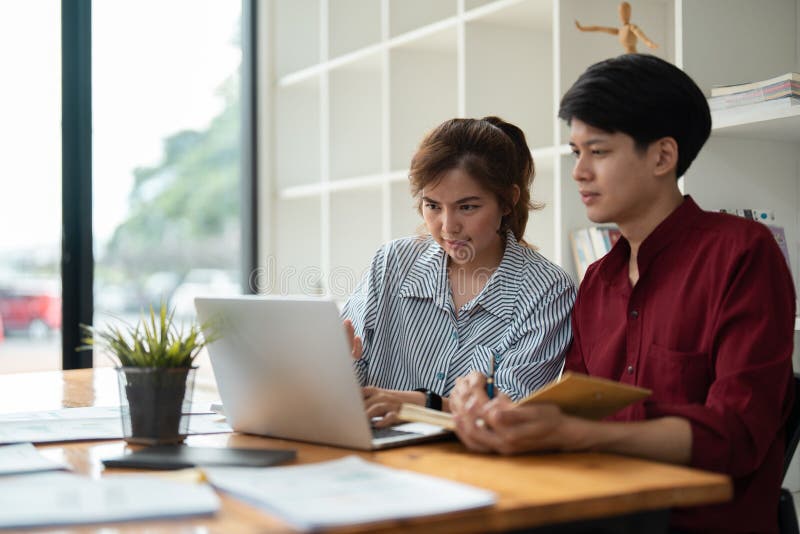 Junge Fachleute arbeiten an einem Projekt in einem modernen Büroumfeld mit natürlichem Licht zusammen lizenzfreies stockbild