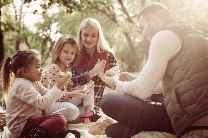 Junge Familie, die Picknick am Herbsttag hat lizenzfreie stockbilder Junge Familie, die Picknick am Herbsttag hat lizenzfreie stockbilder