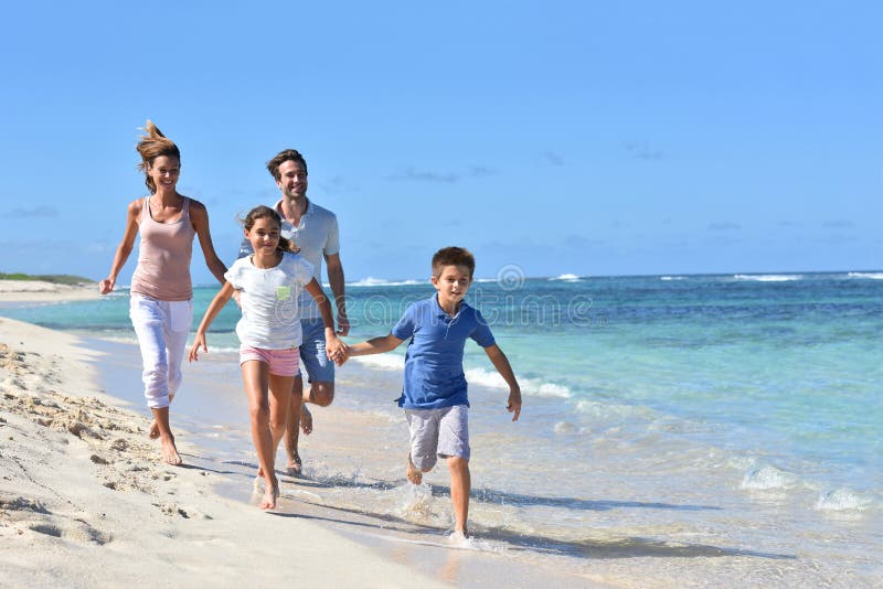Junge Familie, die Sommerferien genießend läuft lizenzfreie stockfotos Junge Familie, die Sommerferien genießend läuft lizenzfreie stockfotos