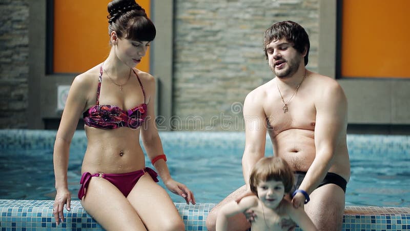 Junge Familie im Pool Eltern mit Sohnschwimmen und -spiel im Pool