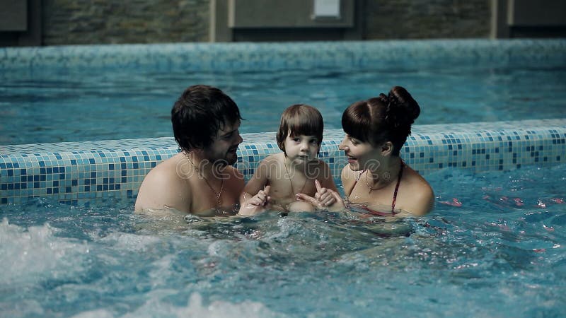 Junge Familie im Pool Eltern mit Sohnschwimmen und -spiel im Pool