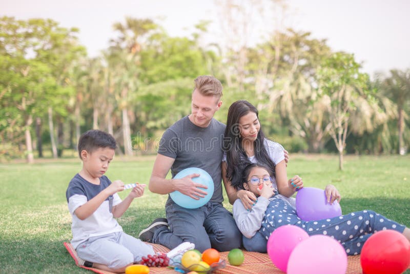Junge Familie mit den Kindern, die Spaß in der Natur haben stockbild Junge Familie mit den Kindern, die Spaß in der Natur haben stockbild