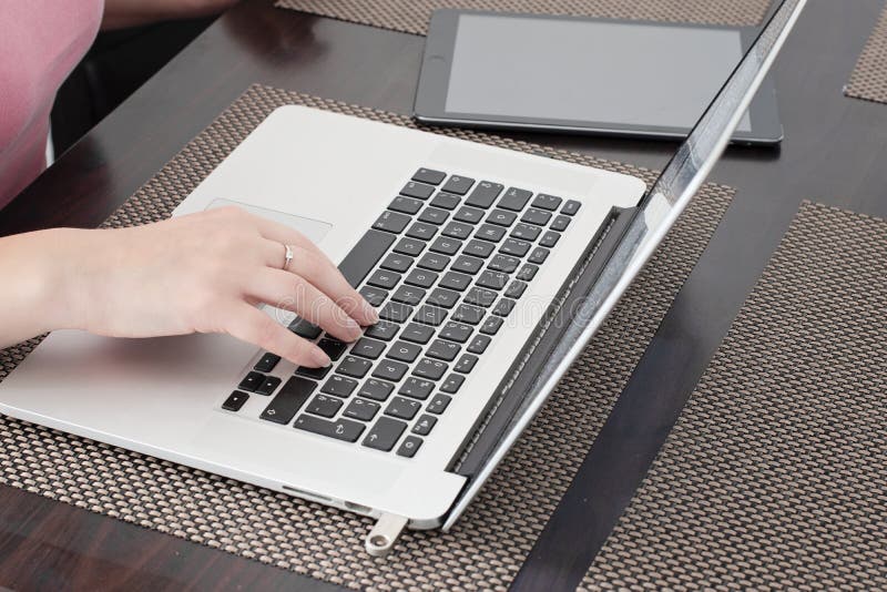 Junge Frau arbeitet an Notizbuch zu Hause lizenzfreies stockbild Junge Frau arbeitet an Notizbuch zu Hause lizenzfreies stockbild