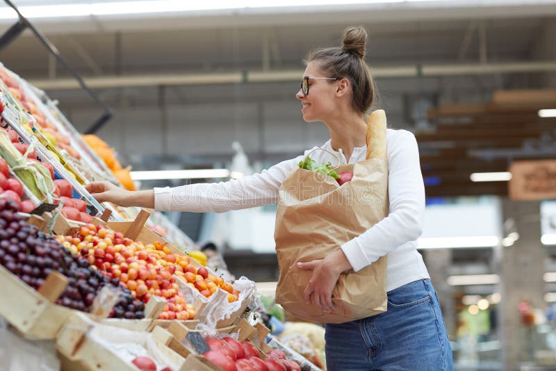 Junge Frau auf Frucht-Stand lizenzfreie stockfotografie Junge Frau auf Frucht-Stand lizenzfreie stockfotografie