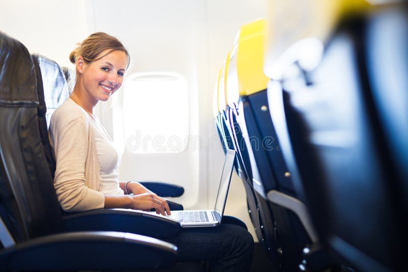 Junge Frau an Bord von einem Flugzeug stockbild Junge Frau an Bord von einem Flugzeug stockbild