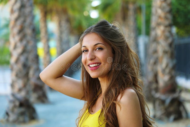 Junge Frau des schönen Brunette, die mit perfektem Lächeln in einem Park wartet auf jemand lächelt lizenzfreie stockbilder Junge Frau des schönen Brunette, die mit perfektem Lächeln in einem Park wartet auf jemand lächelt lizenzfreie stockbilder