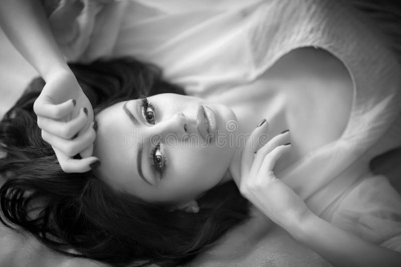 Junge Frau des schönen sexy Brunette, die auf Bett liegt Sinnliche herrliche perfekte Frau, die provozierend, Innenschuß aufwirft lizenzfreies stockfoto Junge Frau des schönen sexy Brunette, die auf Bett liegt Sinnliche herrliche perfekte Frau, die provozierend, Innenschuß aufwirft lizenzfreies stockfoto