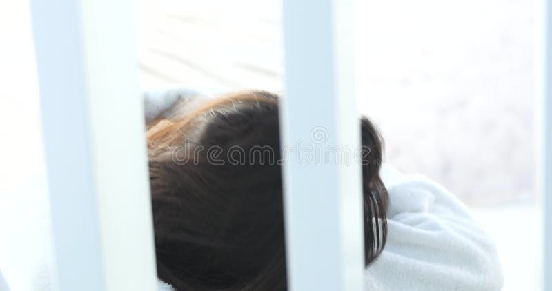 Junge Frau, die auf Massagetabelle am Badekurortsalon liegt