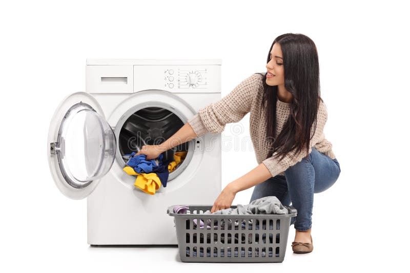 Junge Frau, die eine Waschmaschine leert lizenzfreie stockfotografie