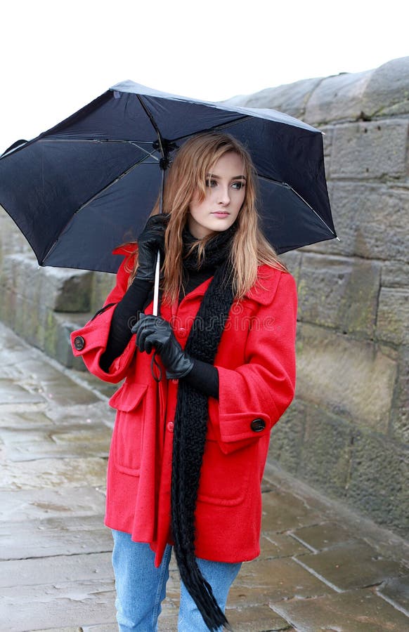 Junge Frau, die einen Regenschirm vom Schneeregen und vom Regen hält stockfotos Junge Frau, die einen Regenschirm vom Schneeregen und vom Regen hält stockfotos
