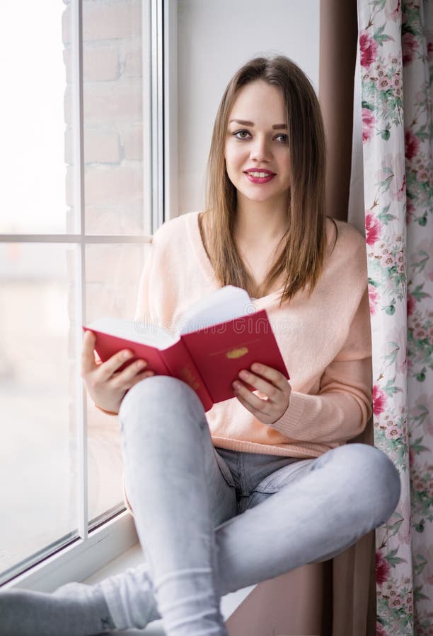 Frau Sitzt Auf Fenster Und Dem Lesen Stockfoto Bild von
