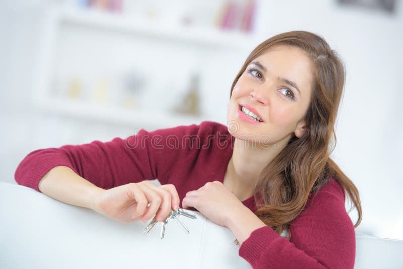 Junge Frau, die Hausschlüssel hält lizenzfreie stockfotografie