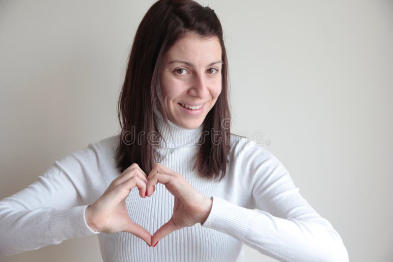 Junge Frau, die Herzsymbol mit den Händen macht stockfotografie Junge Frau, die Herzsymbol mit den Händen macht stockfotografie