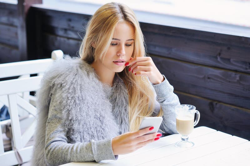 Junge Frau, die ihre Zeit während der Kaffeepause genießt lizenzfreies stockbild Junge Frau, die ihre Zeit während der Kaffeepause genießt lizenzfreies stockbild
