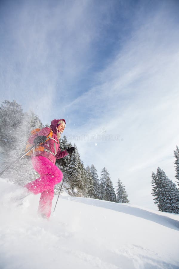 Junge Frau, die im Hochgebirge snowshoeing ist stockfotografie Junge Frau, die im Hochgebirge snowshoeing ist stockfotografie