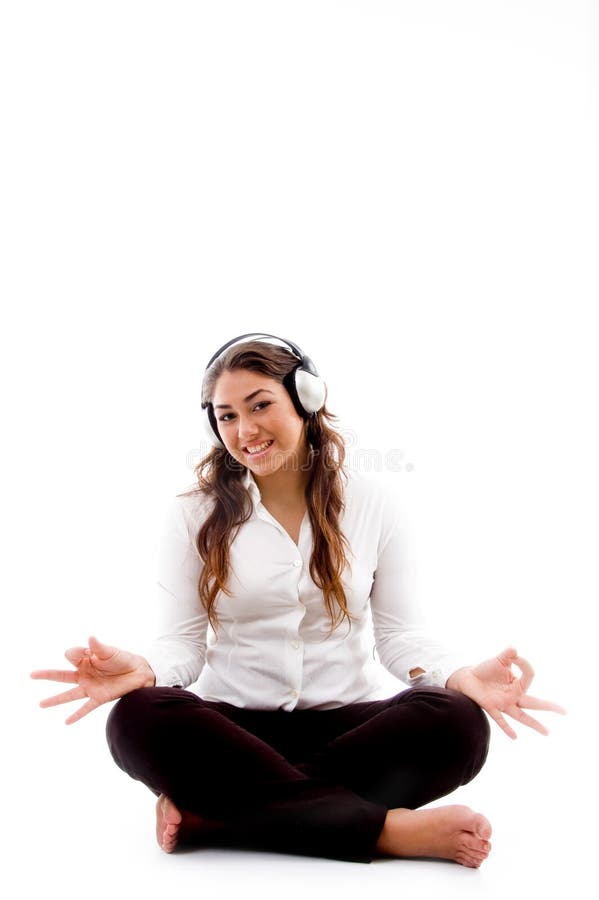 Junge Frau, die Meditation mit Musik tut lizenzfreies stockbild Junge Frau, die Meditation mit Musik tut lizenzfreies stockbild