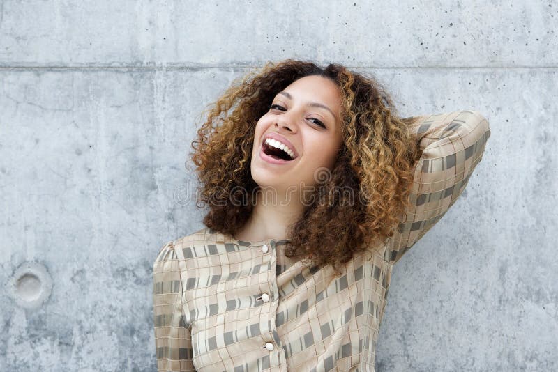 Junge Frau, die mit der Hand im Haar lächelt stockfotografie Junge Frau, die mit der Hand im Haar lächelt stockfotografie