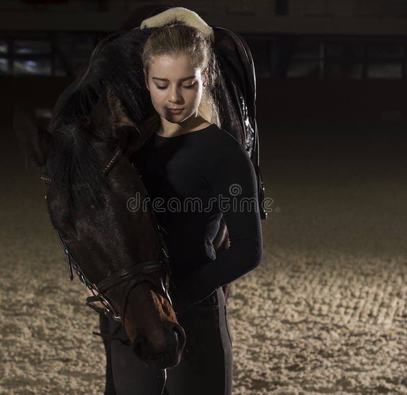 Junge Frau, die mit ihrem Pferd steht stockfoto Junge Frau, die mit ihrem Pferd steht stockfoto