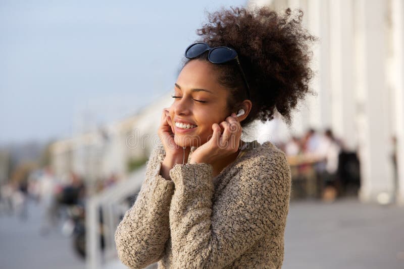 Close up portrait of a young woman enjoying music on earphones. Close up portrait of a young woman enjoying music on earphones