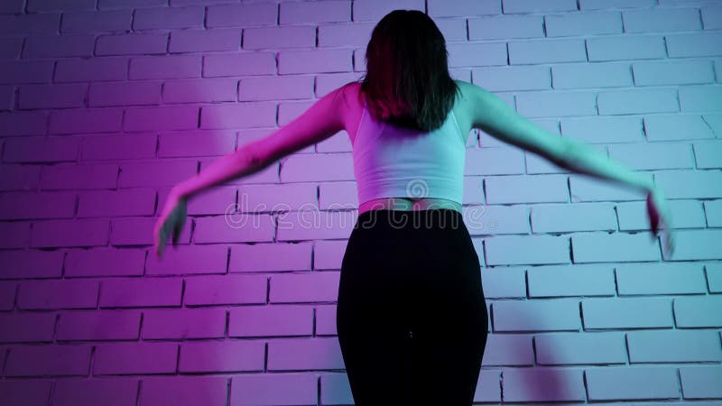 Junge Frau, die Pille macht, wärmt ihren Körper bei Neonbeleuchtung