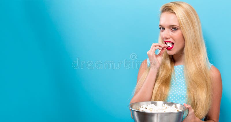 Junge Frau, die Popcorn isst
