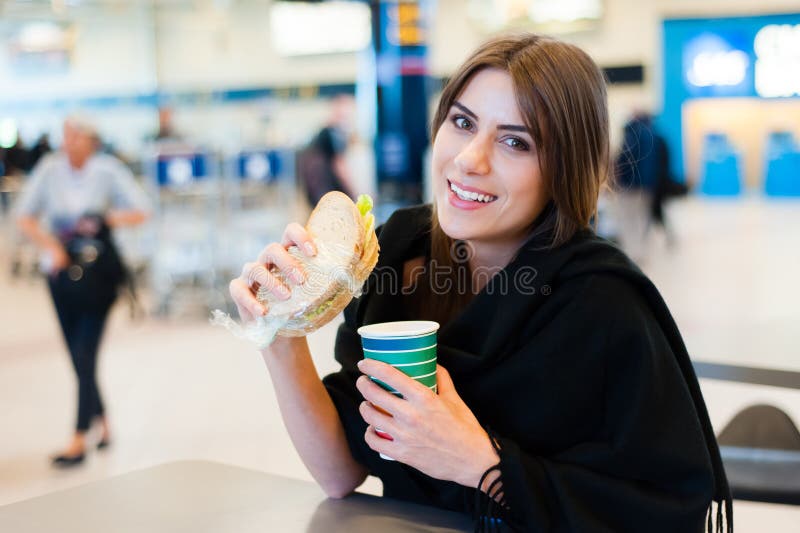 Junge Frau an einem Restaurant im internationalen Flughafen stockbilder Junge Frau an einem Restaurant im internationalen Flughafen stockbilder