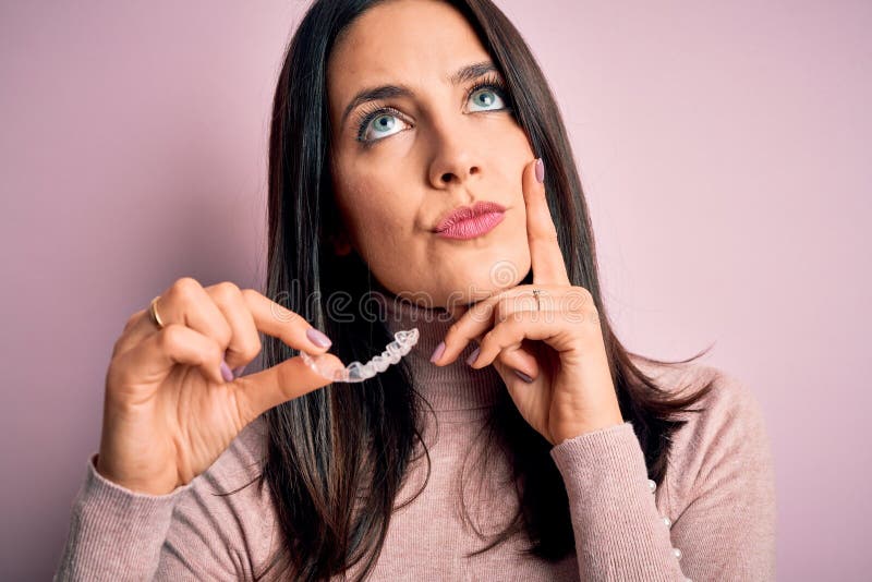 Junge Frau mit blauen Augen mit klarer Ausrichtung über rosa Hintergrund seriöses Gesicht denkt über Frage sehr verwirrt lizenzfreies stockfoto