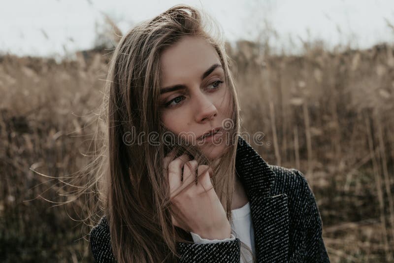 Junge Frau mit dem langen blonden Haar sprechend am Telefon im Freien lizenzfreie stockbilder Junge Frau mit dem langen blonden Haar sprechend am Telefon im Freien lizenzfreie stockbilder