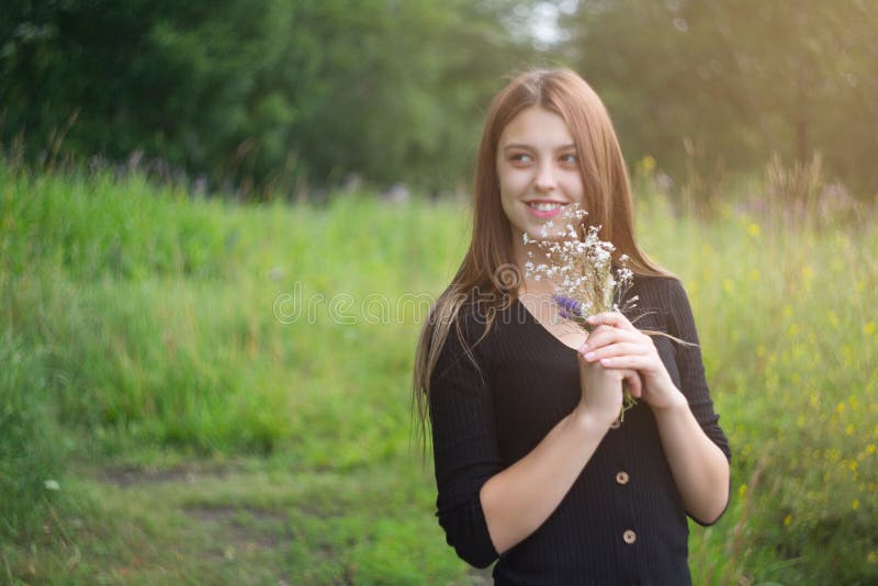 Junge Frau mit einem kleinen Blumenstrauß im Freien. lizenzfreie stockbilder