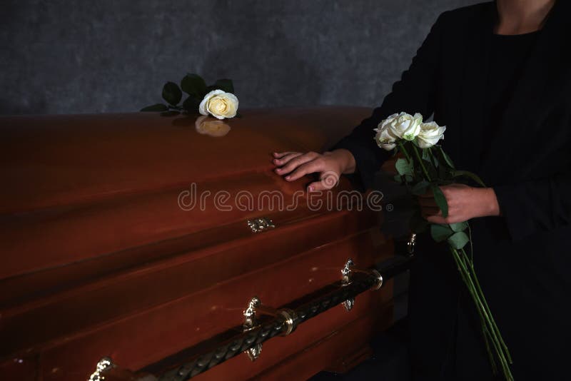 Junge Frau mit weißen Rosen nahe Schatulle im Beerdigungsinstitut stockfoto Junge Frau mit weißen Rosen nahe Schatulle im Beerdigungsinstitut stockfoto