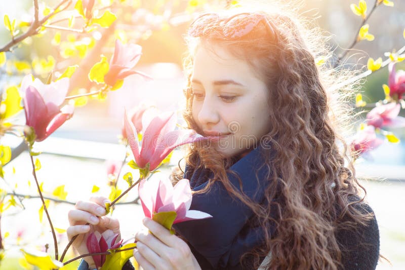 Junge Frau nahe blühendem Park des Magnolienblumen-Baums im Frühjahr am sonnigen Tag Schönes glückliches Mädchen, das Geruch in e stockfoto Junge Frau nahe blühendem Park des Magnolienblumen-Baums im Frühjahr am sonnigen Tag Schönes glückliches Mädchen, das Geruch in e stockfoto