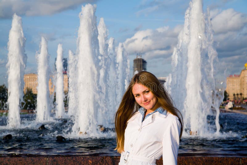 Junge Frau nahe dem Brunnen lizenzfreie stockfotos Junge Frau nahe dem Brunnen lizenzfreie stockfotos