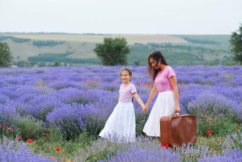 Junge Frau und M?dchen gehen durch das Lavendelblumenfeld, sch?ne Sommerlandschaft lizenzfreies stockbild Junge Frau und M?dchen gehen durch das Lavendelblumenfeld, sch?ne Sommerlandschaft lizenzfreies stockbild