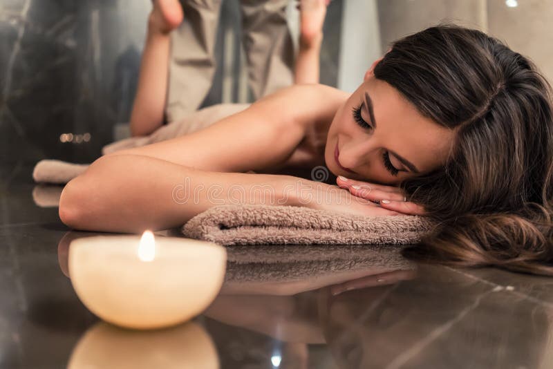 Junge Frau, welche die ausdehnenden Techniken der thailändischen Massage genießt lizenzfreie stockbilder Junge Frau, welche die ausdehnenden Techniken der thailändischen Massage genießt lizenzfreie stockbilder