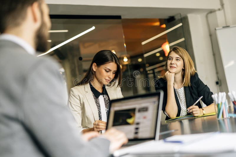 Junge Frauen, die im Büro arbeiten lizenzfreies stockbild Junge Frauen, die im Büro arbeiten lizenzfreies stockbild