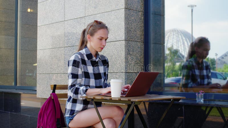 Junge freiberufliche Kopiererin, die auf Laptop tippt