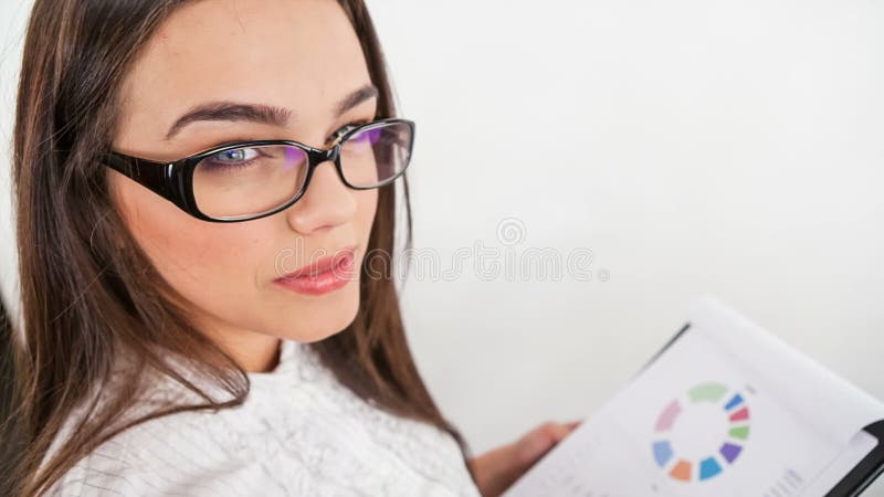 Junge Geschäftsfrau mit Ansicht der Dokumente in camera