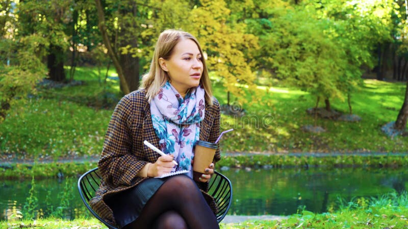 Junge Geschäftsfrauen, die fernarbeiten im Park