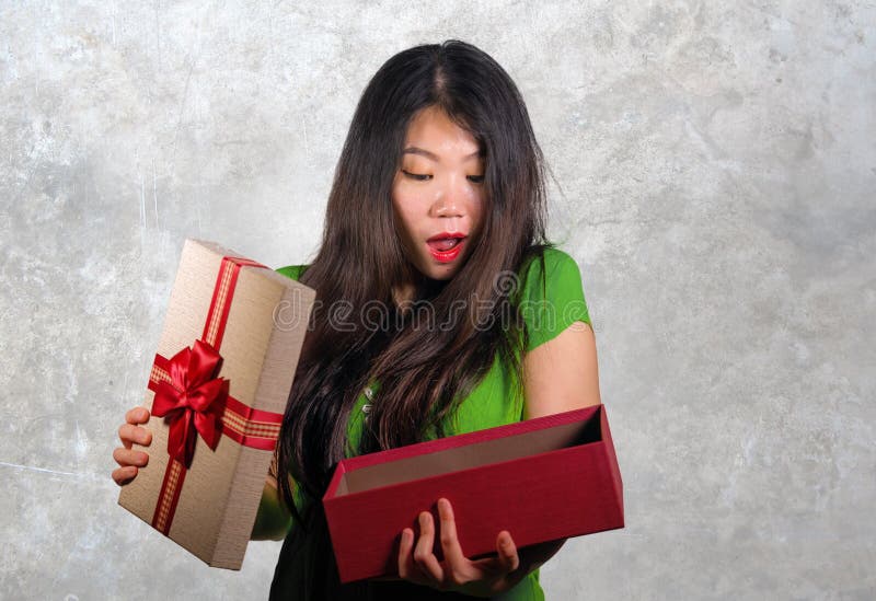 Junge glückliche und schöne asiatische Chinesin, die die Geschenkbox empfängt den Geburtstag oder Weihnachtsgeschenk öffnet das P stockbilder Junge glückliche und schöne asiatische Chinesin, die die Geschenkbox empfängt den Geburtstag oder Weihnachtsgeschenk öffnet das P stockbilder