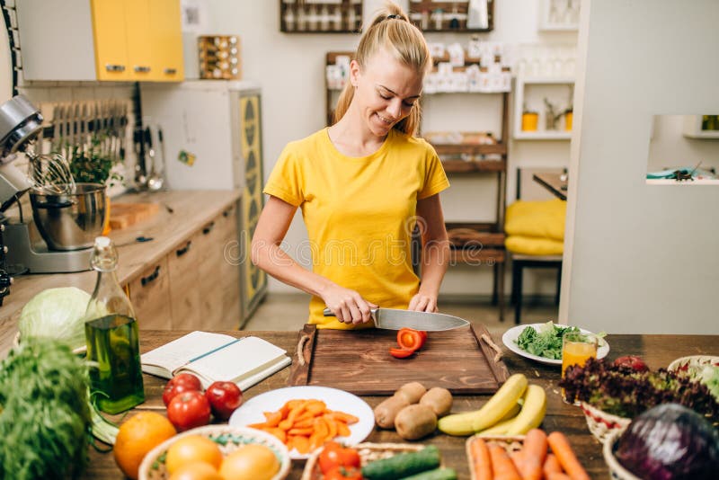 Junge Hausfrau, die auf der Küche, eco Lebensmittel kocht lizenzfreie stockbilder Junge Hausfrau, die auf der Küche, eco Lebensmittel kocht lizenzfreie stockbilder