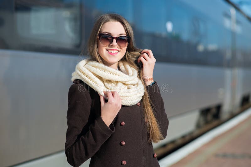 Junge hübsche Station der Frau im Zug lizenzfreie stockfotos Junge hübsche Station der Frau im Zug lizenzfreie stockfotos