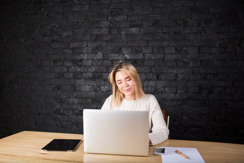 Junge hübsche Studentin, die im Internet über Laptop-Computer lernt stockfotografie