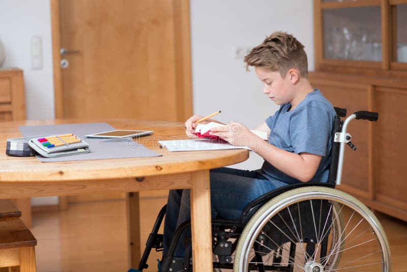 Junge Im Rollstuhl, Der Hausarbeit Tut Und Tabletten-PC Verwendet Stockfoto  - Bild von schularbeit, glücklich: 55300586