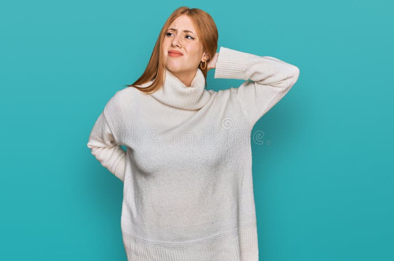 Junge irische Frau mit gelegentlichem Winterschwitz, die an Nackenschmerzen leidet und den Nacken mit Muskelschmerzen berührt lizenzfreie stockbilder