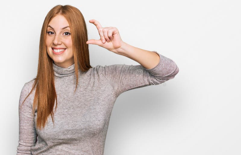 Junge irische Frau mit lockerer Kleidung lächelnd und selbstbewusste Geste mit der Hand machen kleinen Schild mit den Fingern scha lizenzfreies stockfoto